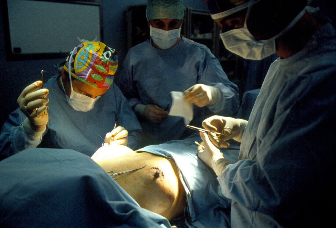 View of surgeons carrying out breast enlargement
