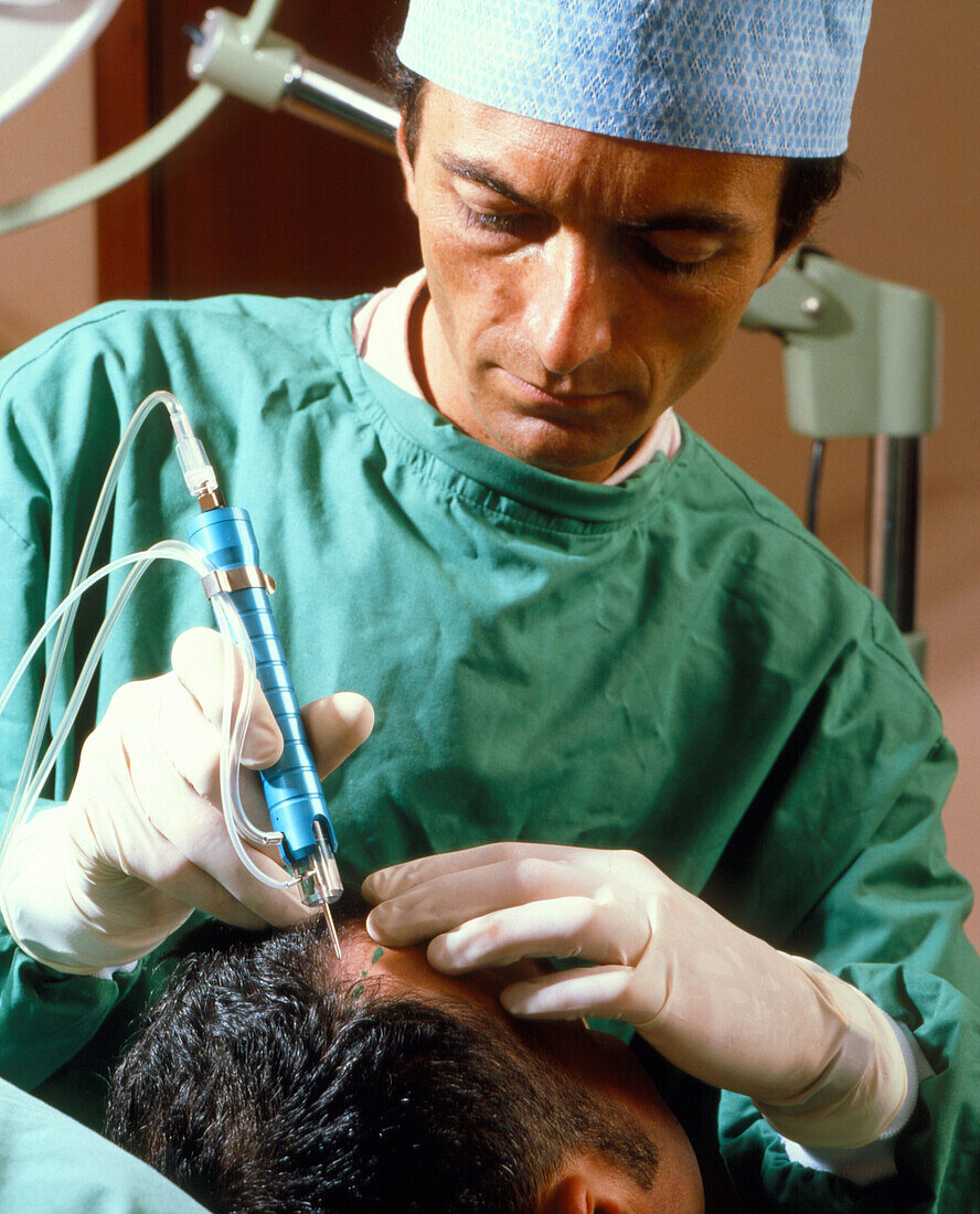Surgeon and man during hair transplant surgery