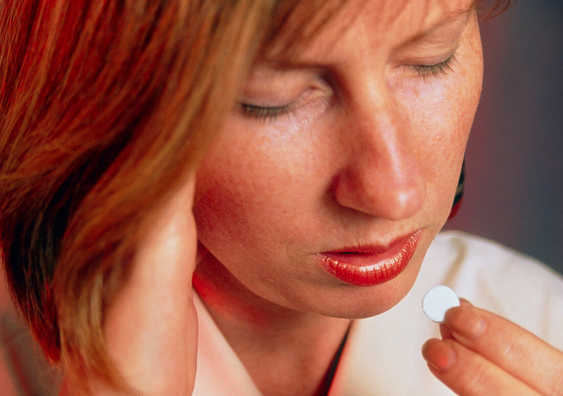 Woman taking a pill to relieve pain