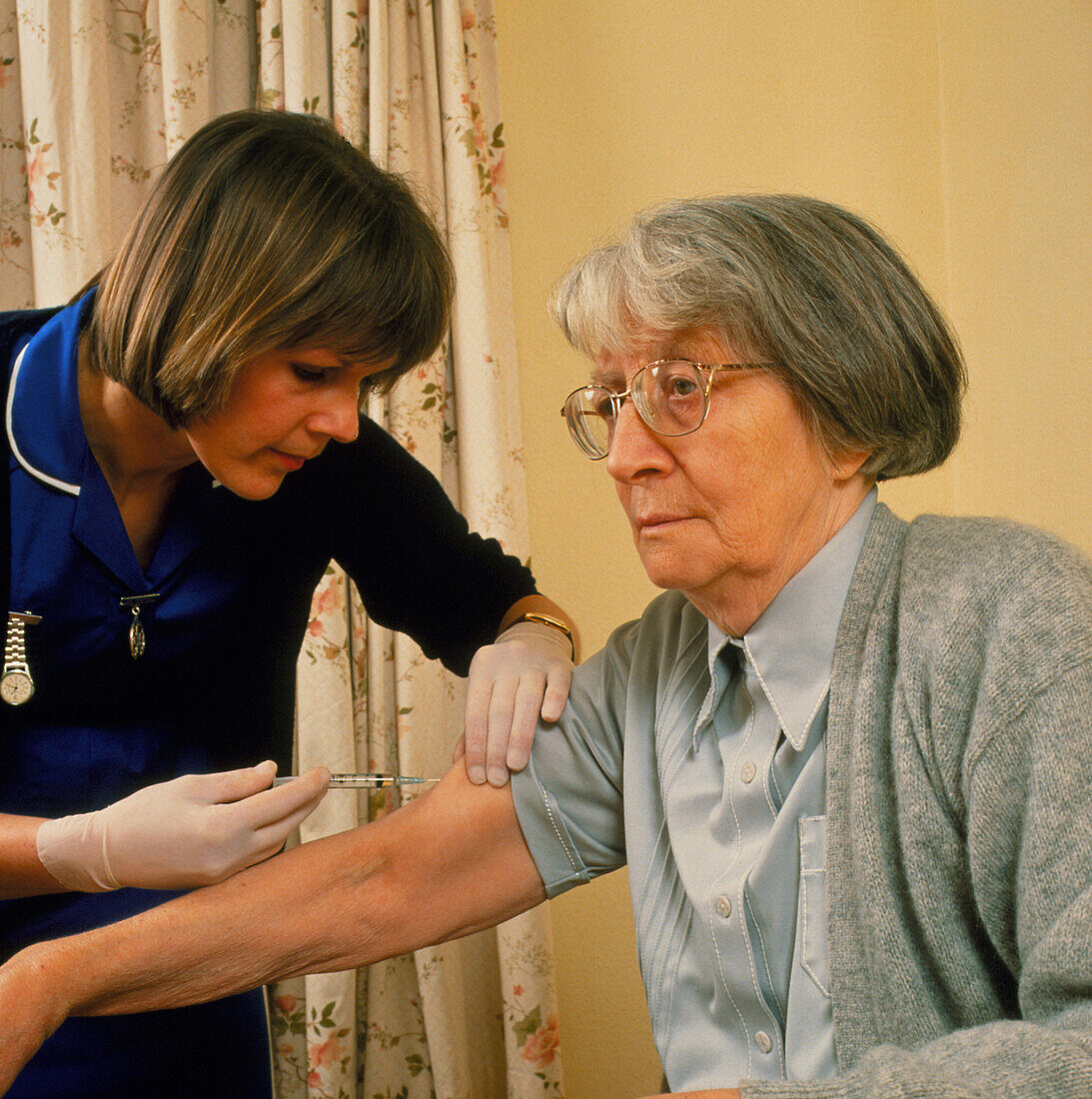Elderly woman given injection by nurse
