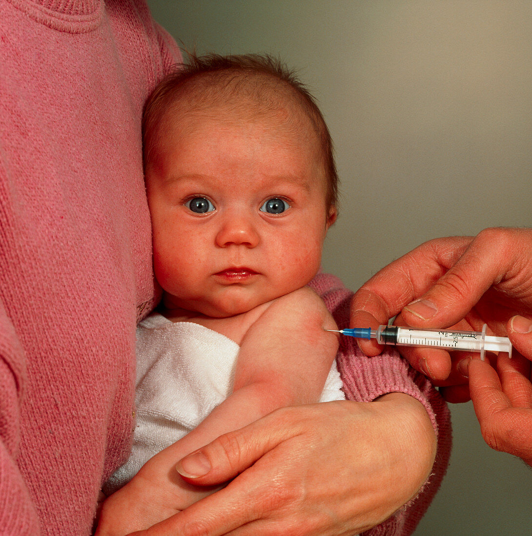 Doctor's hand injecting or vaccinating baby's arm