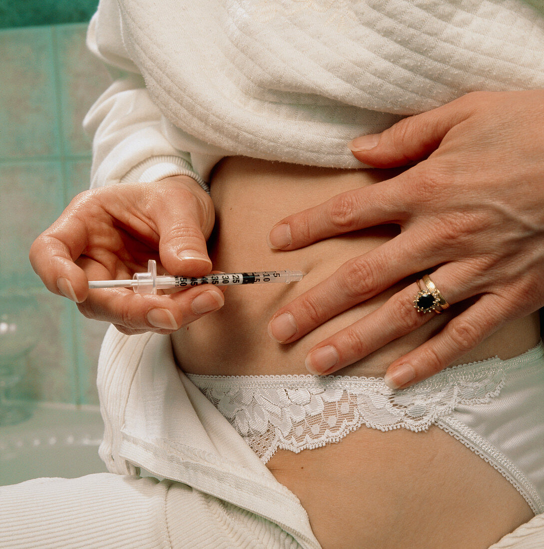 Diabetic woman injects insulin into her abdomen