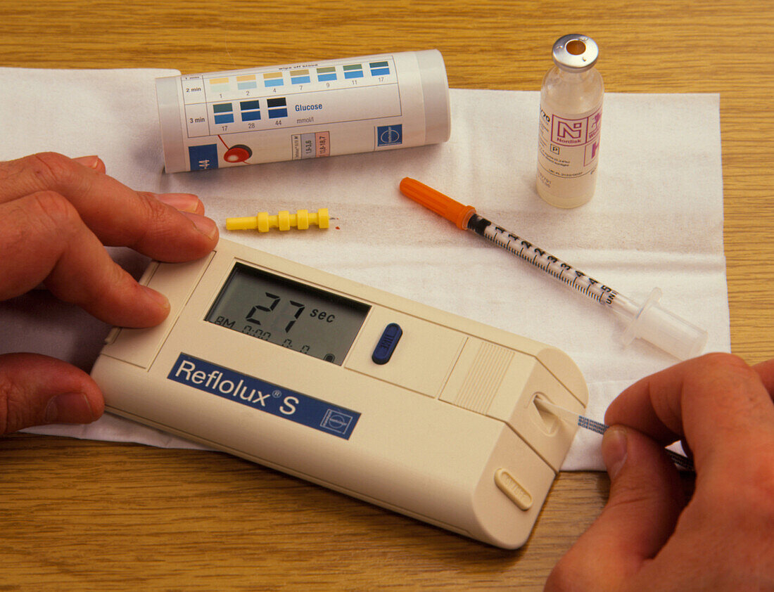 Diabetic tests blood sugar level with strip/meter