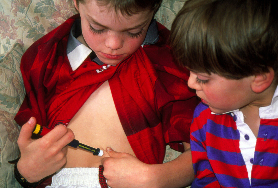 Seven year old boy self-injecting with insulin