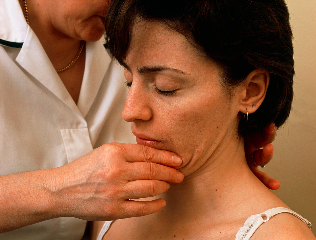 Physiotherapist manipulates female patient's neck