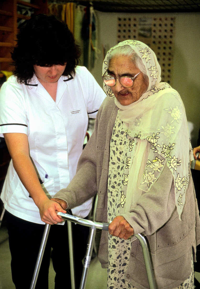Physiotherapist helping an elderly woman walk