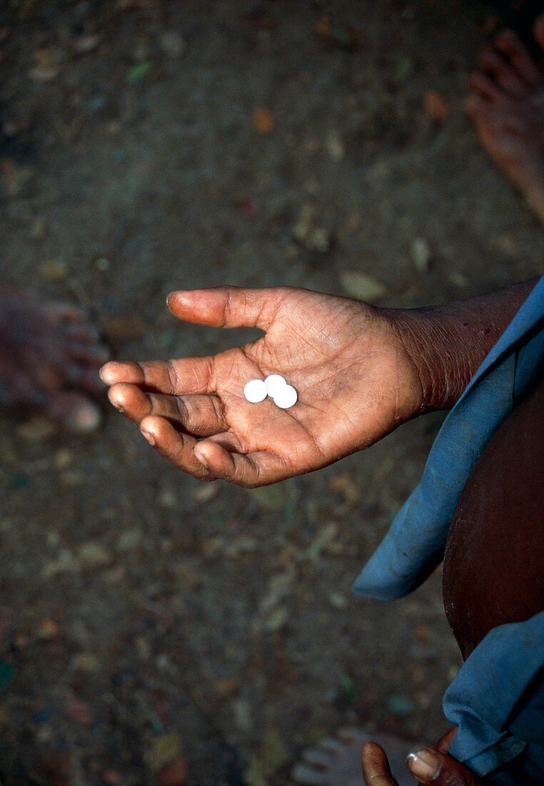 Hand holding pills of elephantiasis drugs