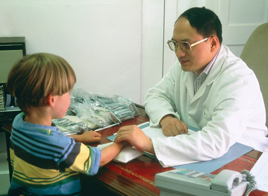 Chinese medicine practitioner takes boy's pulse