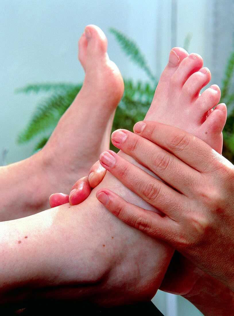 Chiropodist's hands manipulate foot of a patient