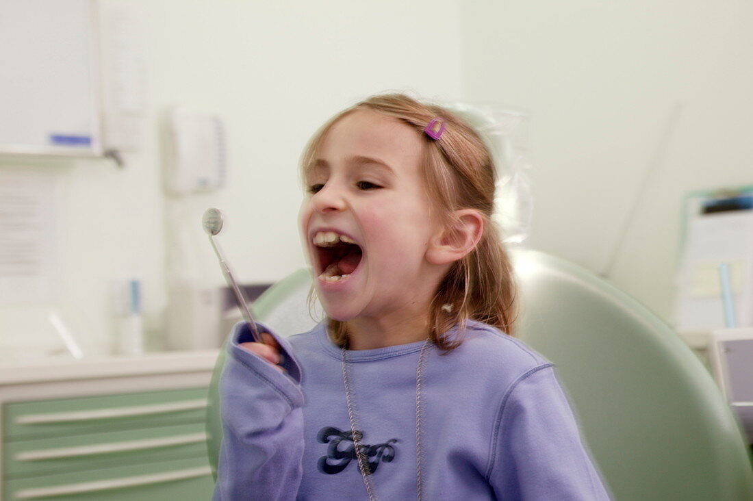 Girl using dental mirror
