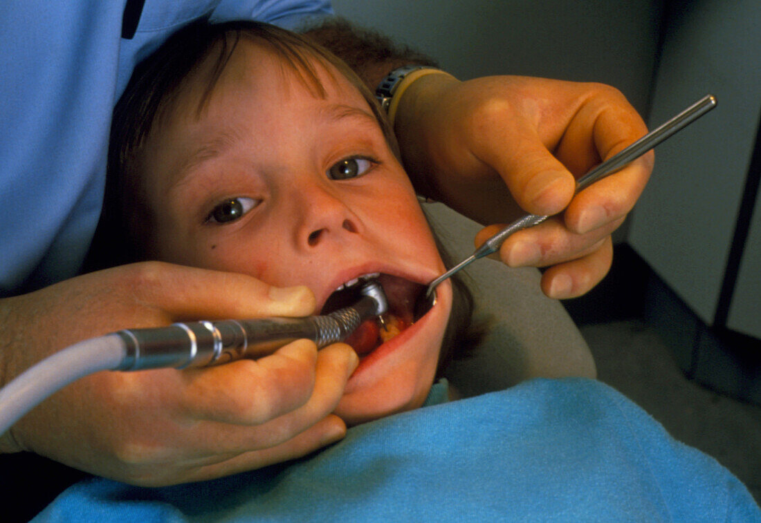 Child at dentist's having tooth drilled