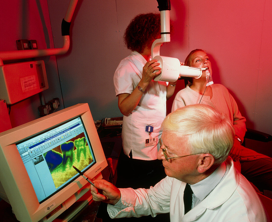 Dentist examining image from computerised X-ray