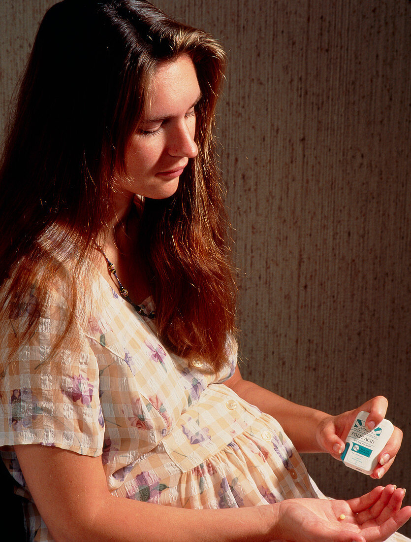 Pregnant woman taking folic acid (vitamin B)