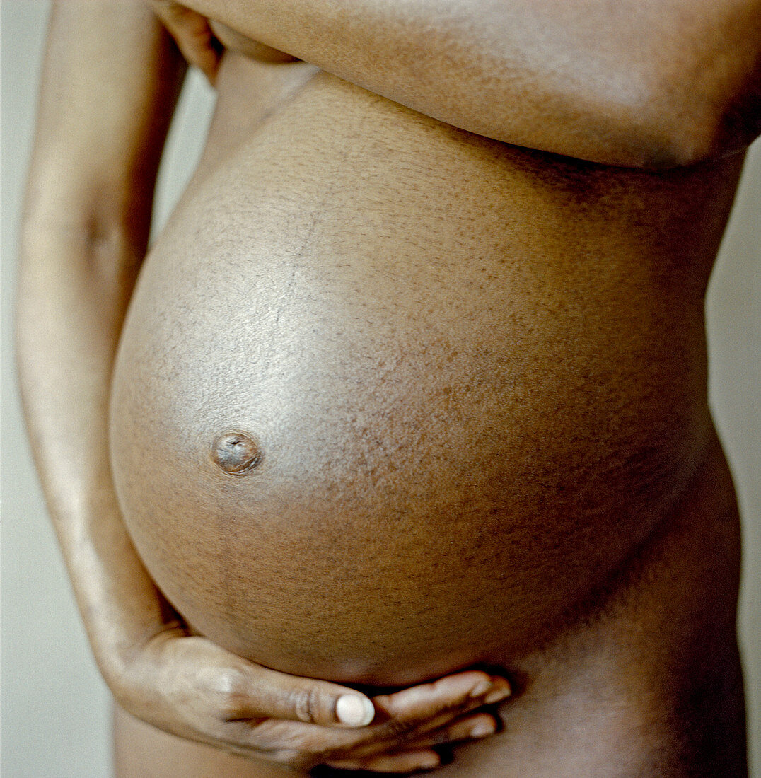 Pregnant woman holding her abdomen