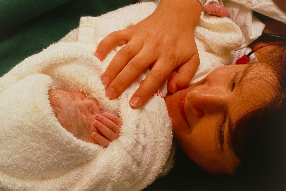 Mum holding her baby after a caesarean delivery