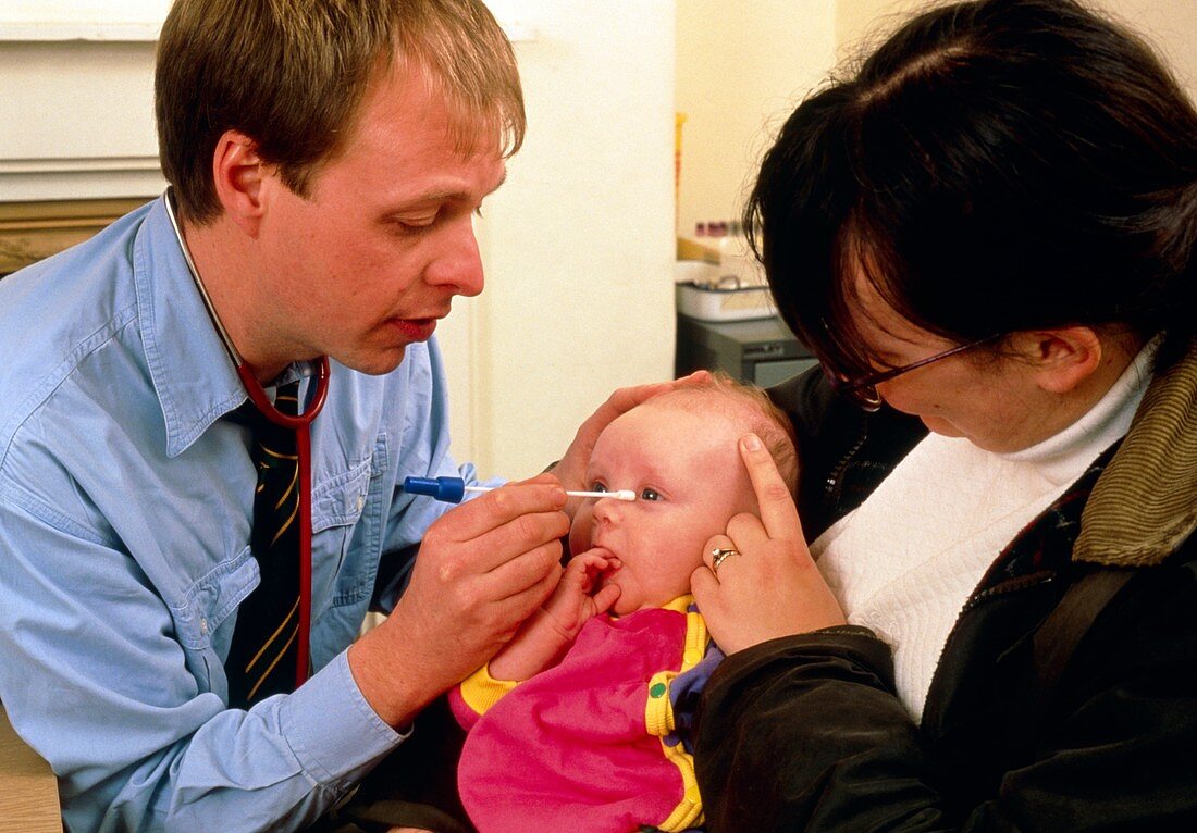 Doctor swabs eye of child with conjunctivitis