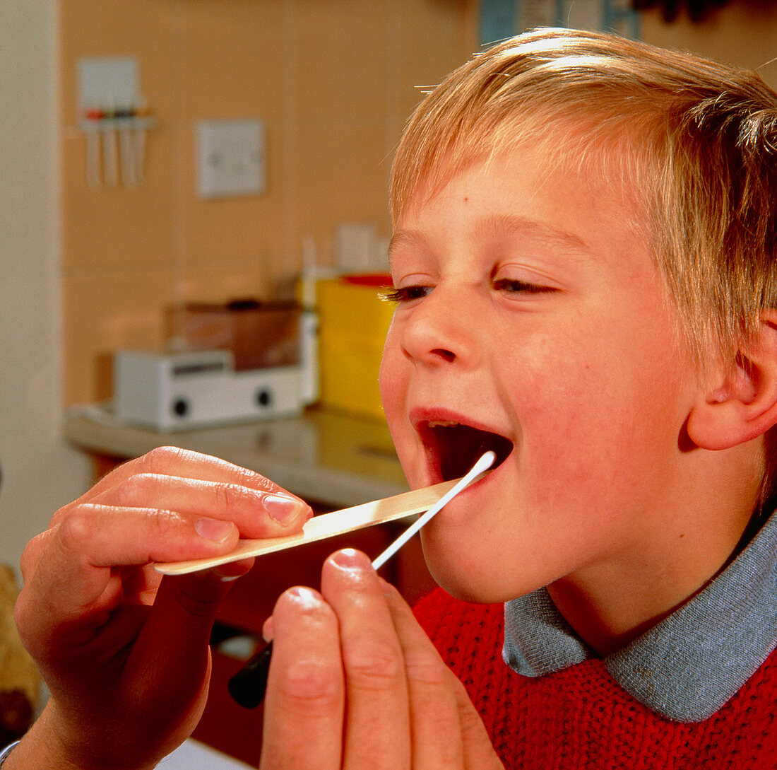 Throat examination of young boy,with swab