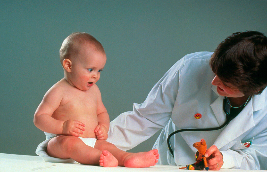 Doctor showing baby a toy