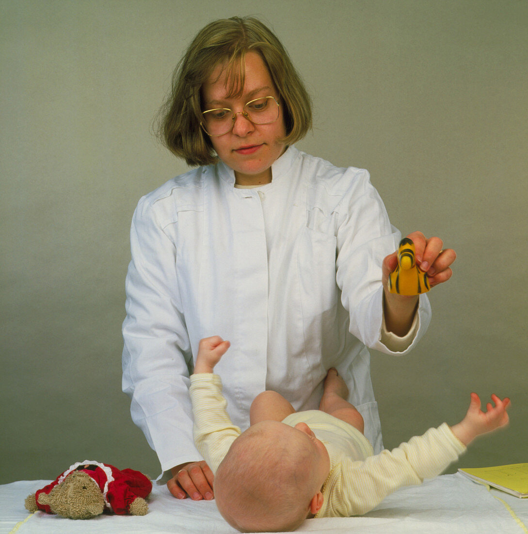 A doctor testing the hearing of a baby