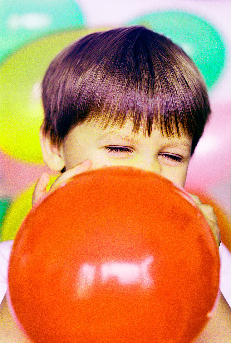 Boy blowing balloon