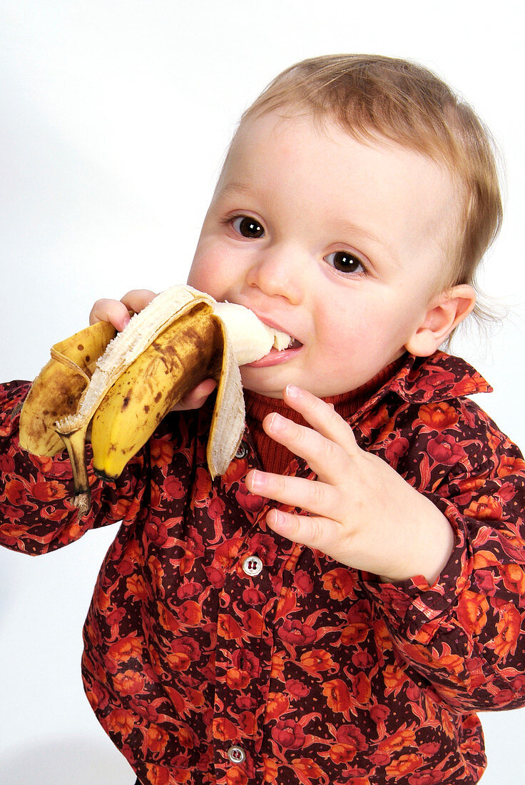 Toddler eating a banana