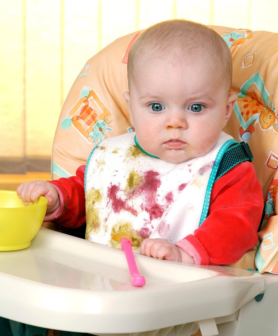 Baby in high chair eating