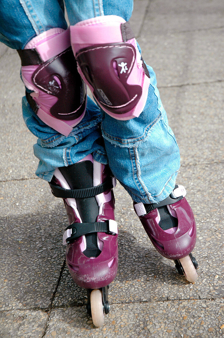 Child wearing rollerblades and knee pads