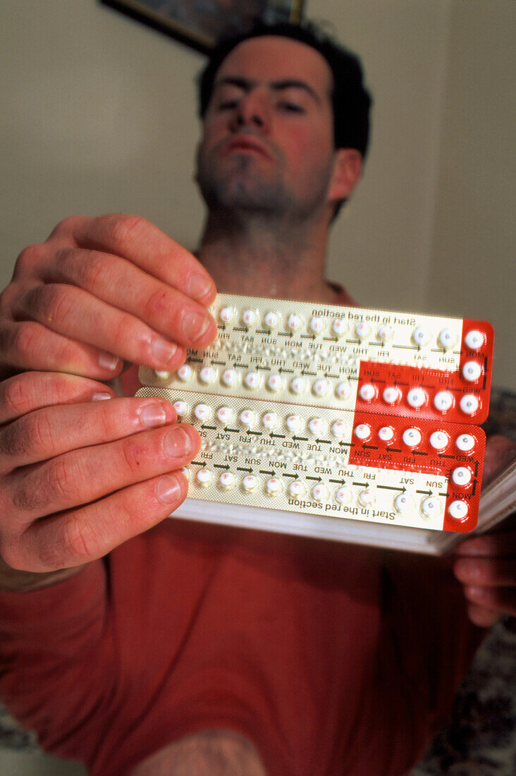 Man holding a packet of female contraceptive pills
