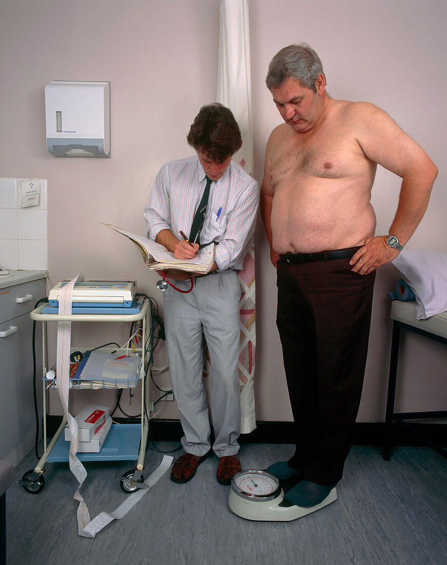 GP doctor records the weight of an obese man
