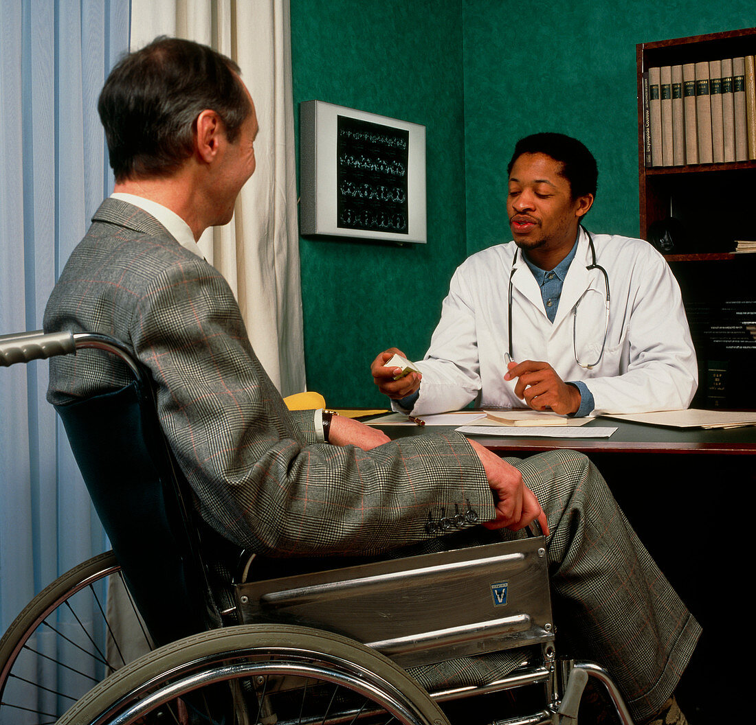 GP doctor discusses prescription with disabled man