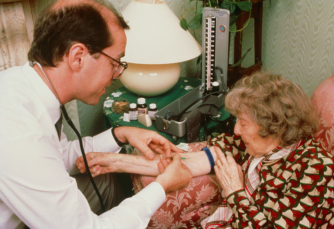 GP giving elderly patient an injection at home