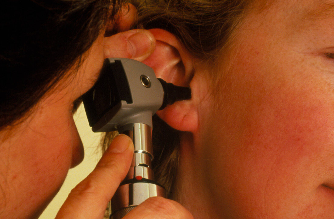 Otoscope ear examination of a woman