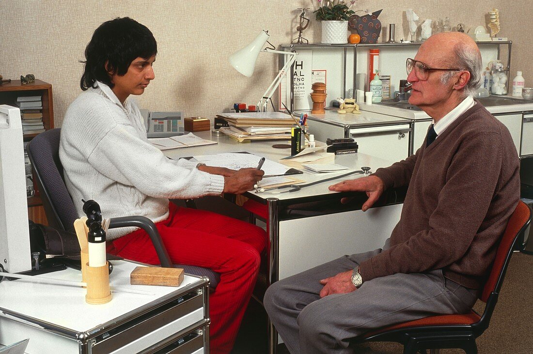Doctor writing a prescription for an elderly man