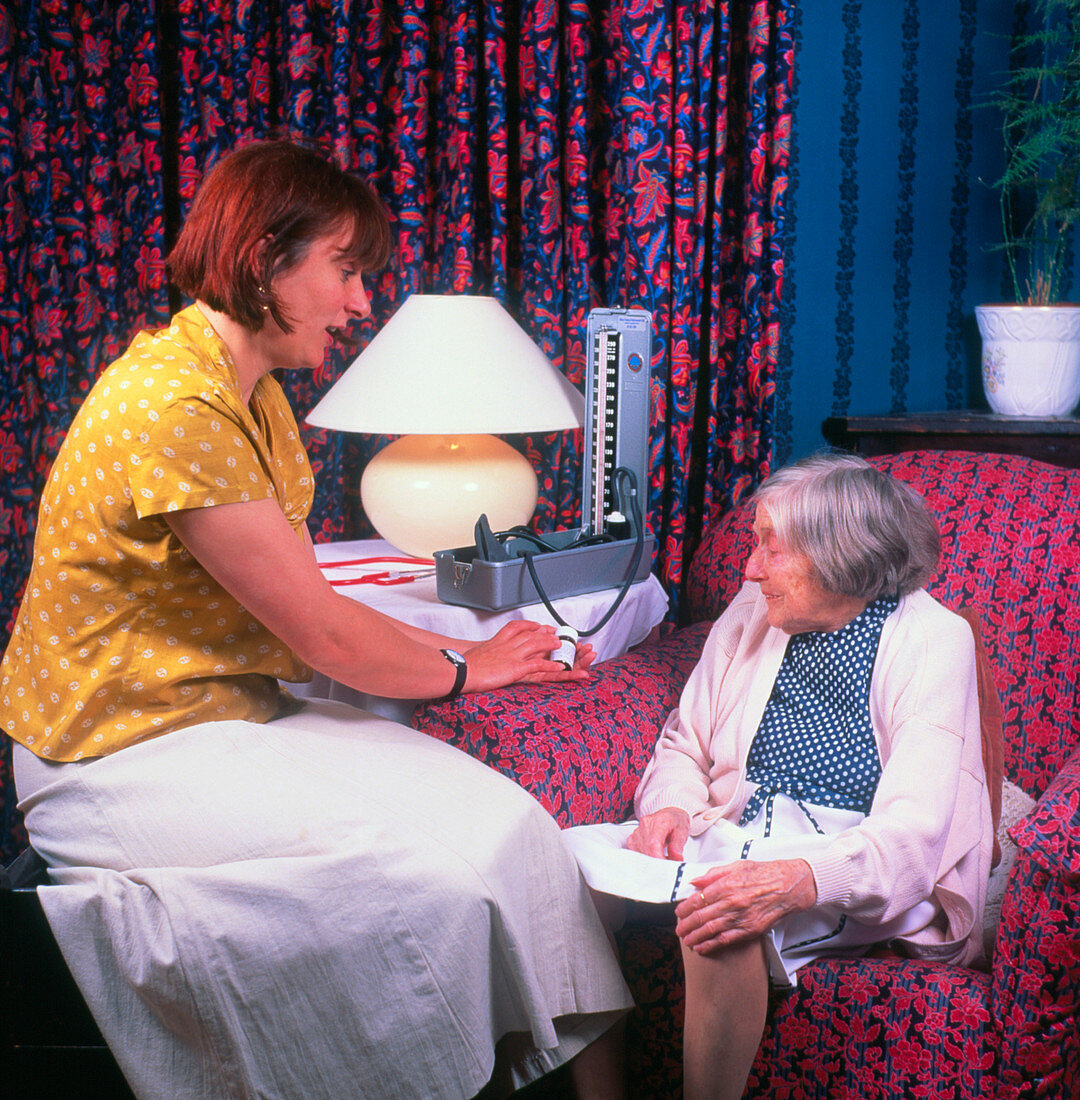 GP explaining use of drugs to elderly patient