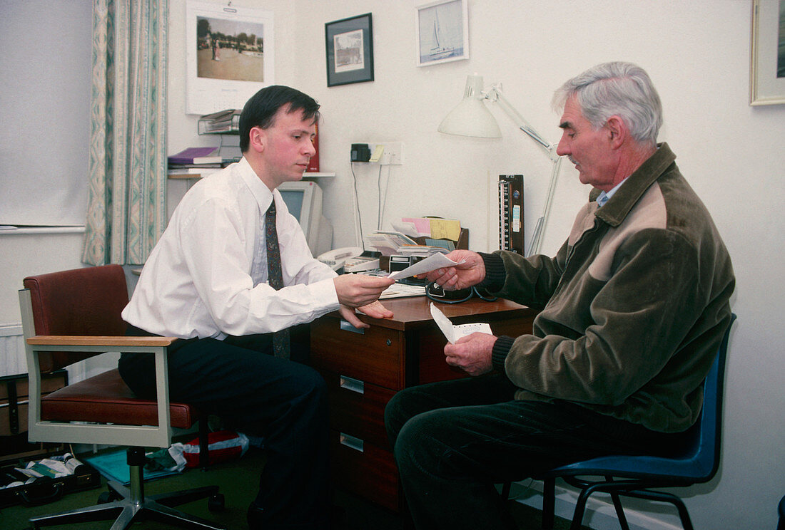 GP doctor hands a prescription to an elderly man