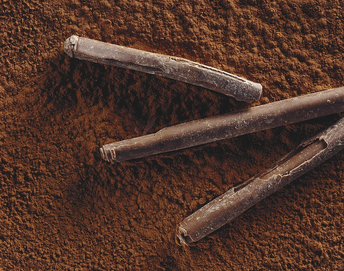 Three chocolate rolls on cocoa powder