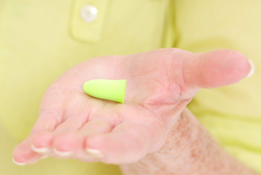 Woman holding an ear plug in her palm