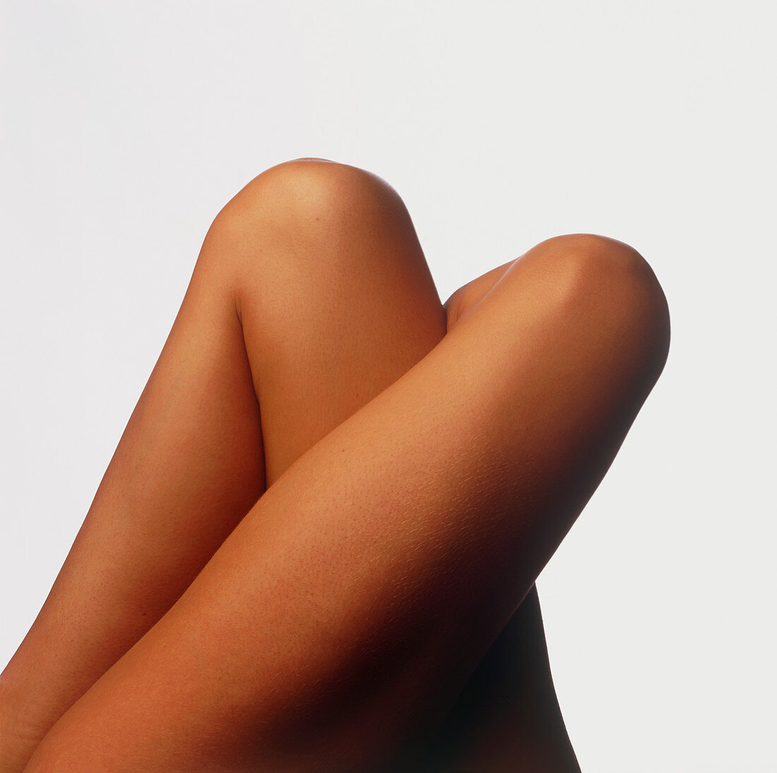 Top view of the tightly crossed legs of a woman