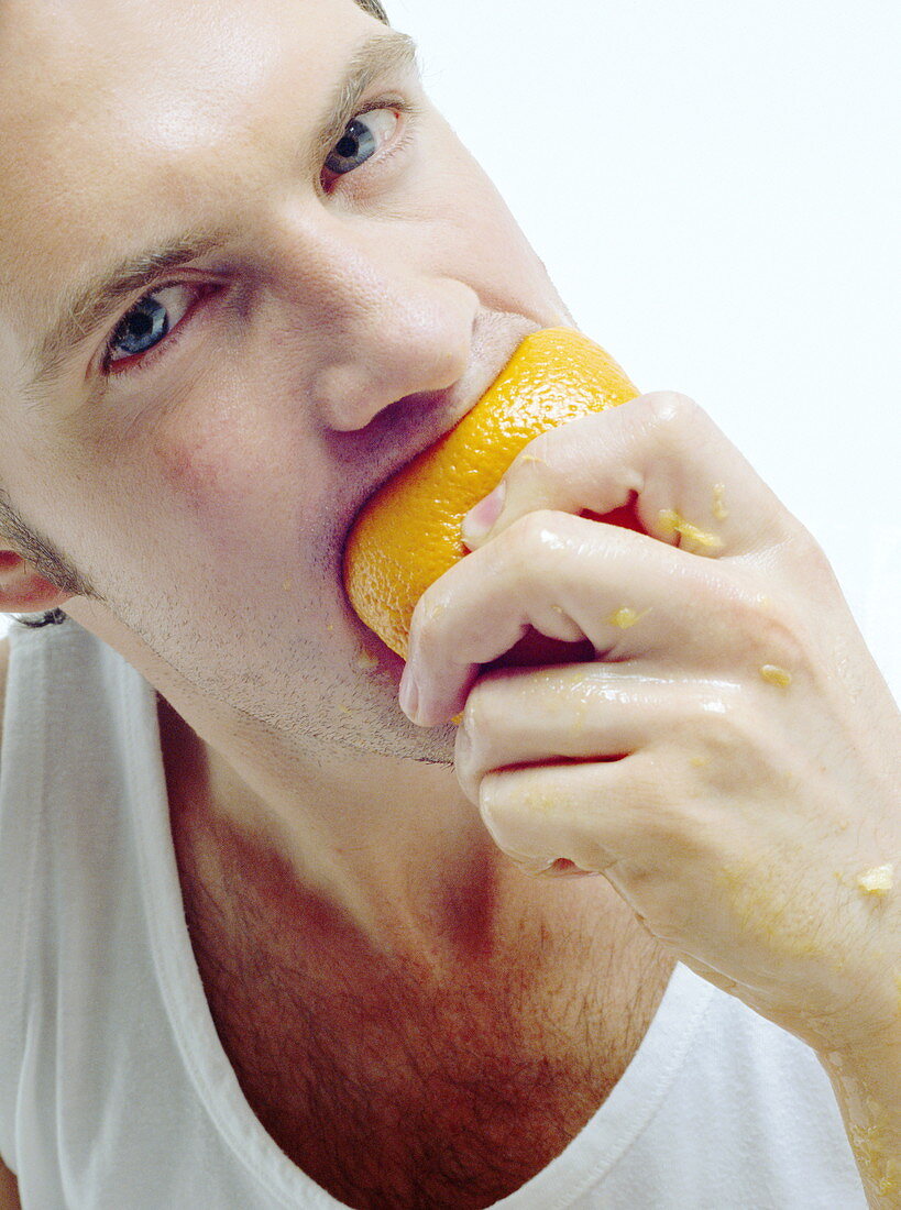 Man eating orange