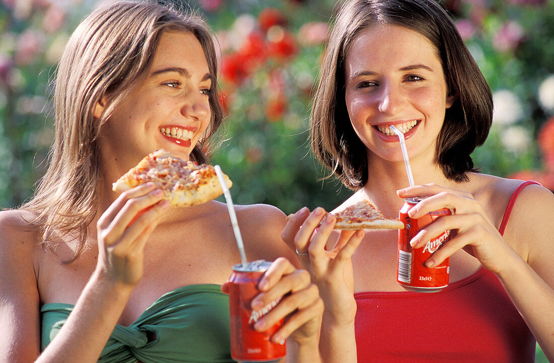 Teenage girls eating pizza
