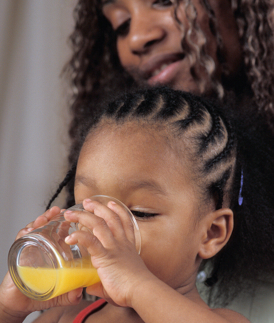 Young girl drinking orange juice