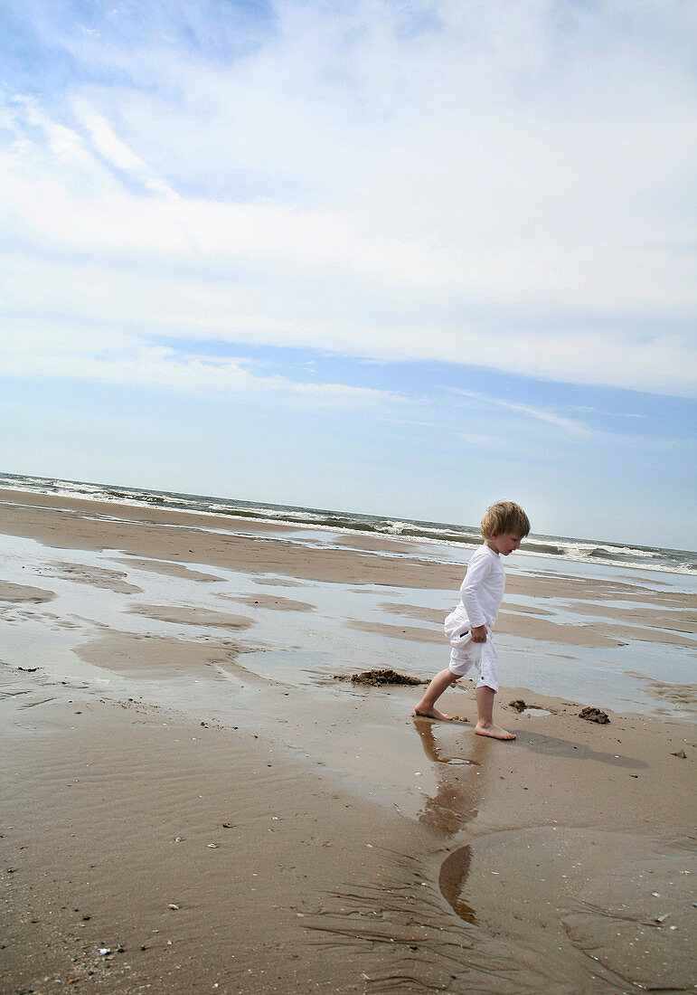 Boy walking on a sandy beach
