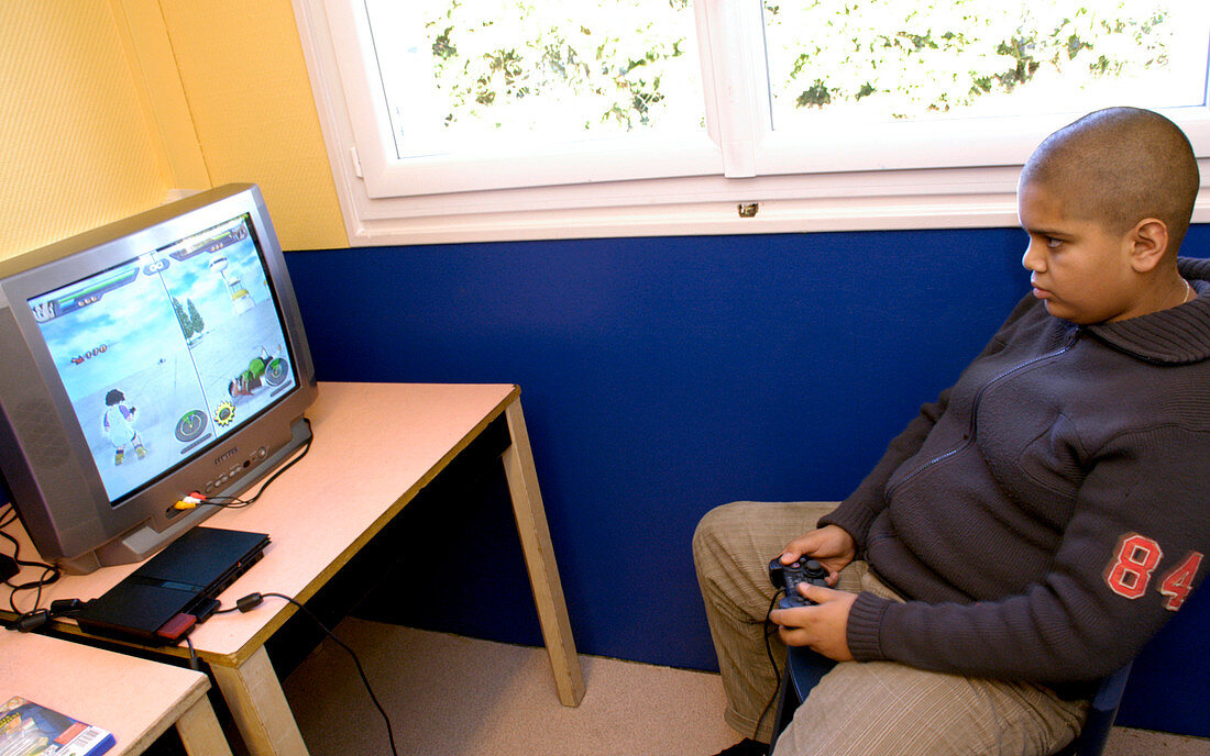 Overweight boy playing a computer game