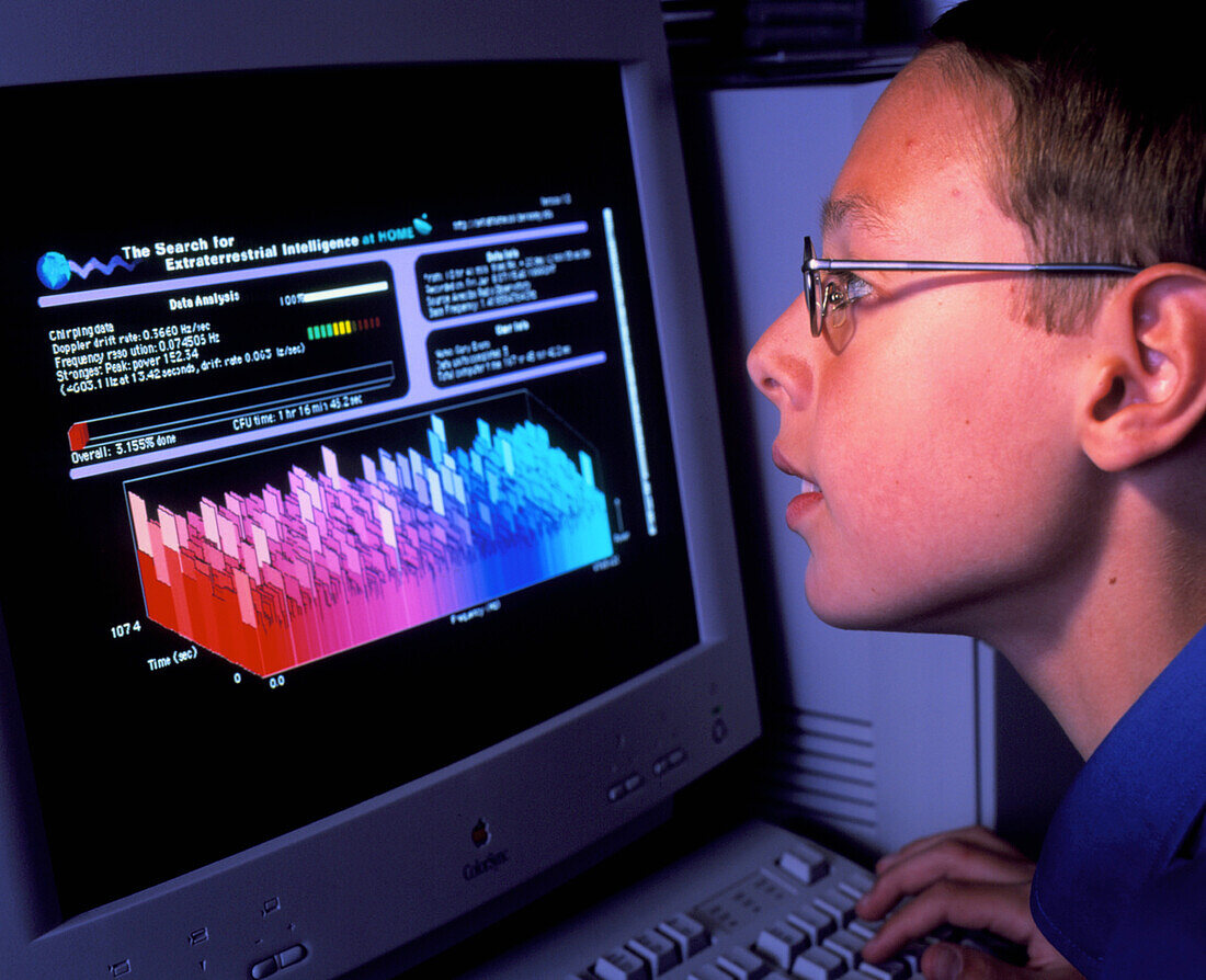Boy at computer displaying SETI@home screen saver