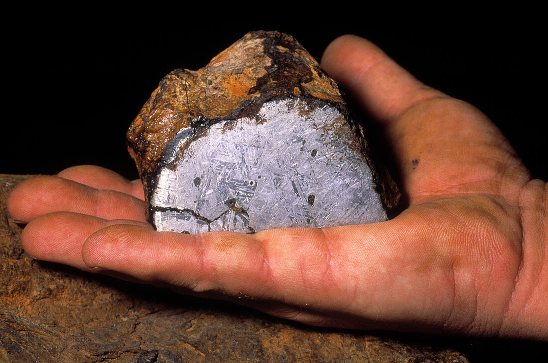 Hand holding an iron meteorite