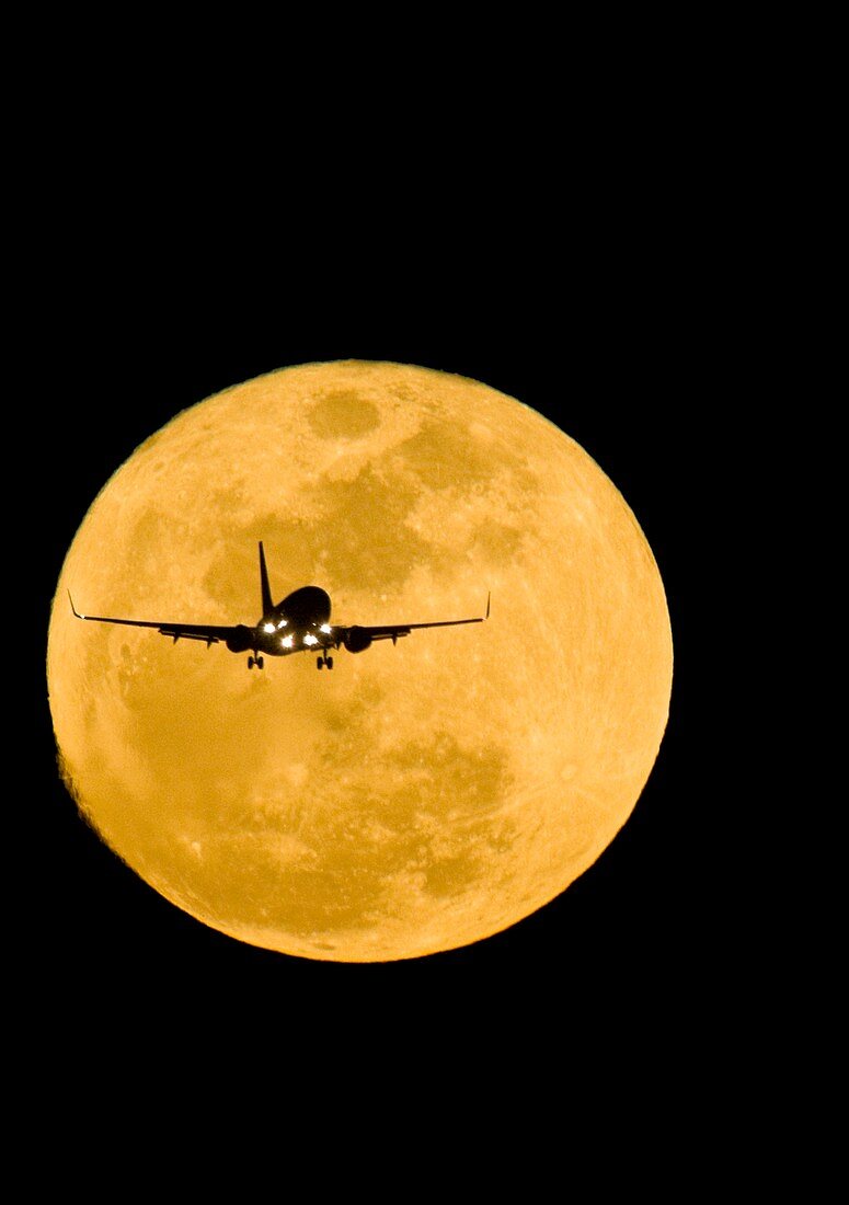 Aeroplane silhouetted against a full moon