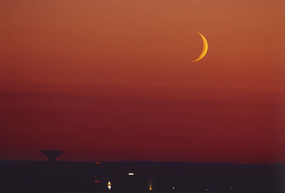 Crescent moon over a satellite dish