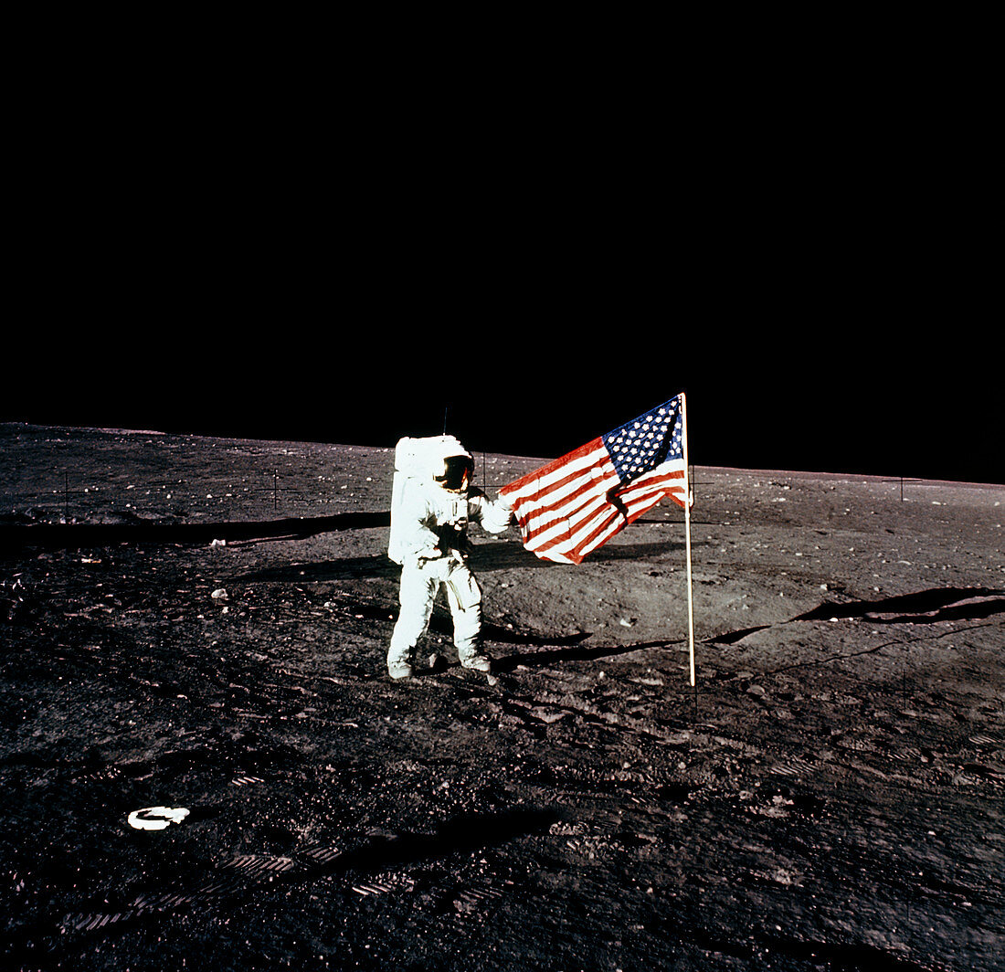 Apollo 12 astronaut unfurls American flag