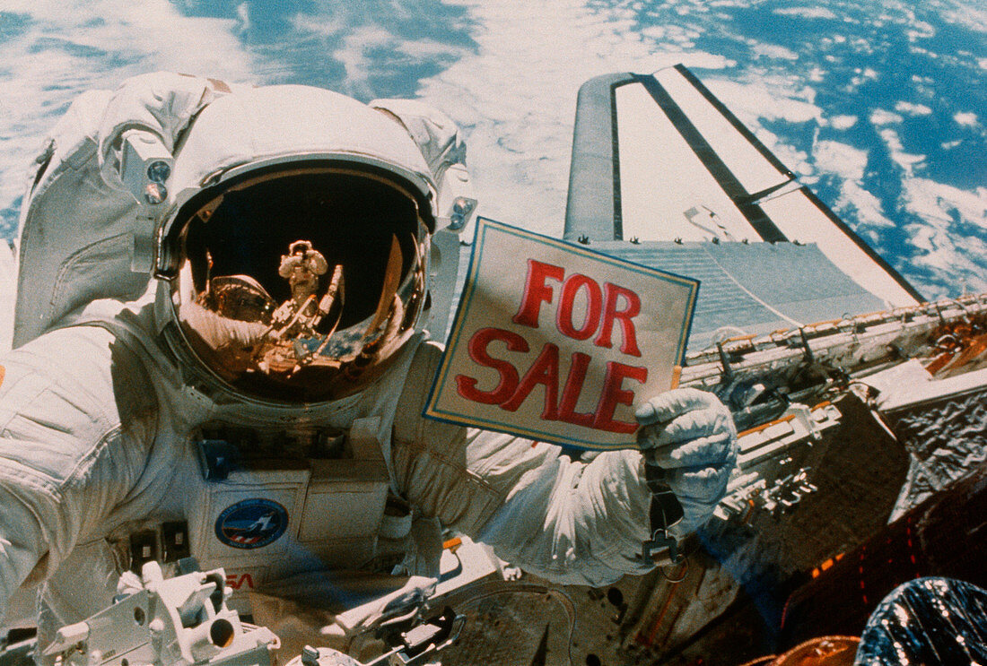 Astronaut holding 'for sale' sign
