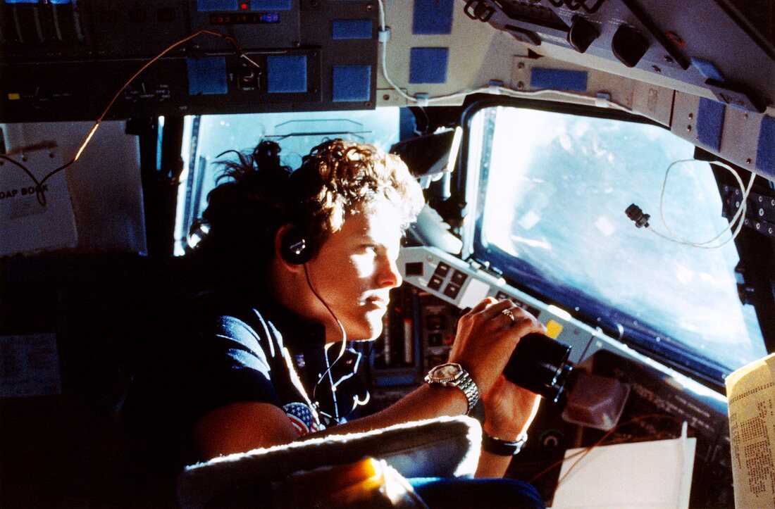 Astronaut viewing Earth through binoculars